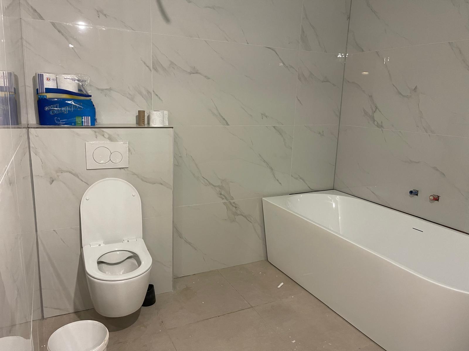 Badkamer renovatie toilet en ligbad marmer tegels - Sanitro Waasland