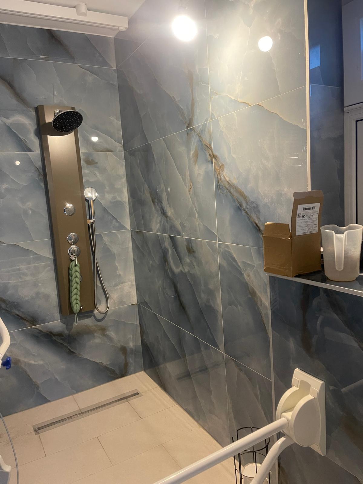 Luxe douche installatie met regenpaneel en natuursteen tegels - Sanitro Sint-Niklaas